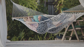 Features for the BH-411 Man wearing sunglasses relaxing outside in a Bliss Hammocks 60-inch Wide Polyester Rope Hammock with spreader bars.