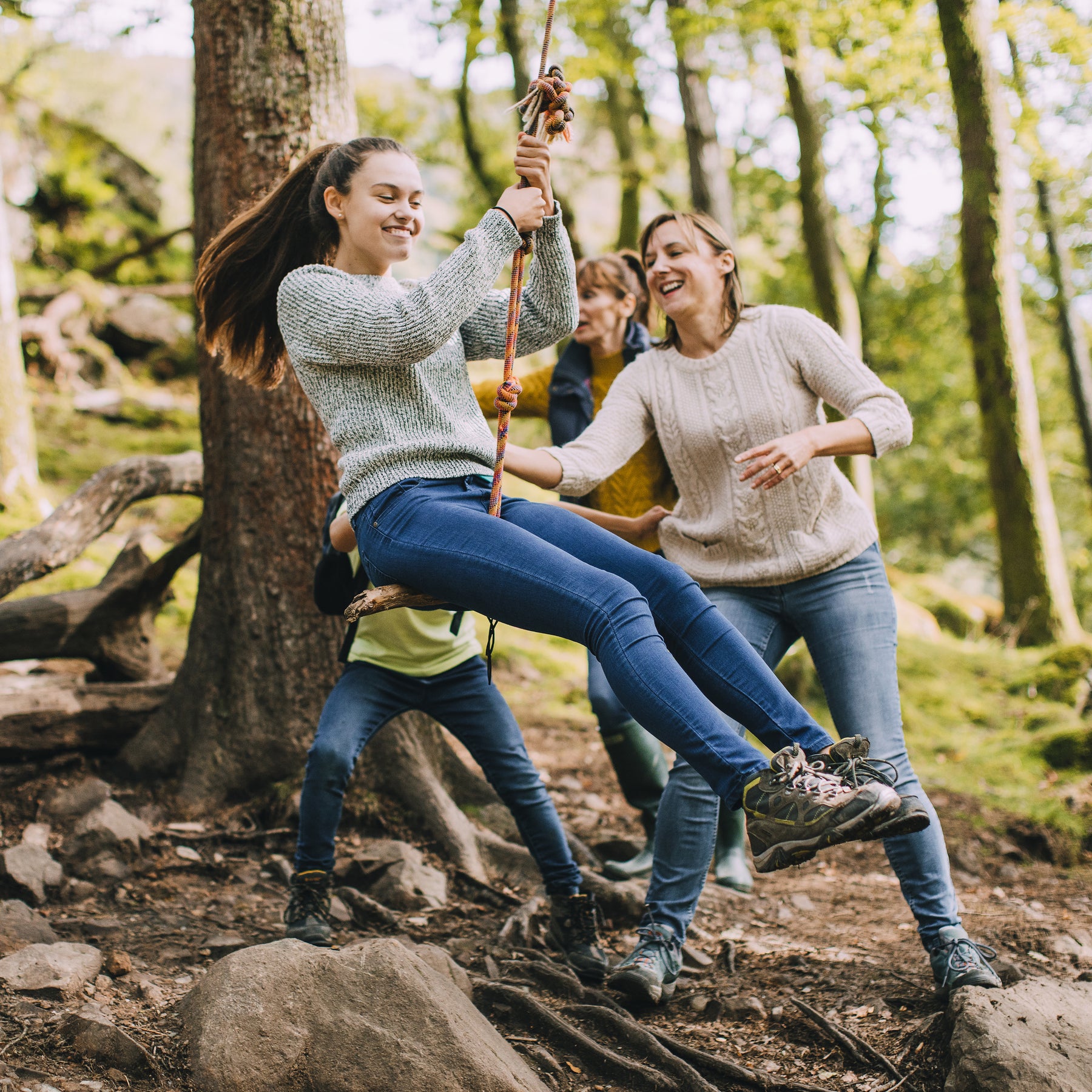 Mom pushing her daughter on the Bliss Outdoors Rope Climber Swing that is hanging from a tree outside.