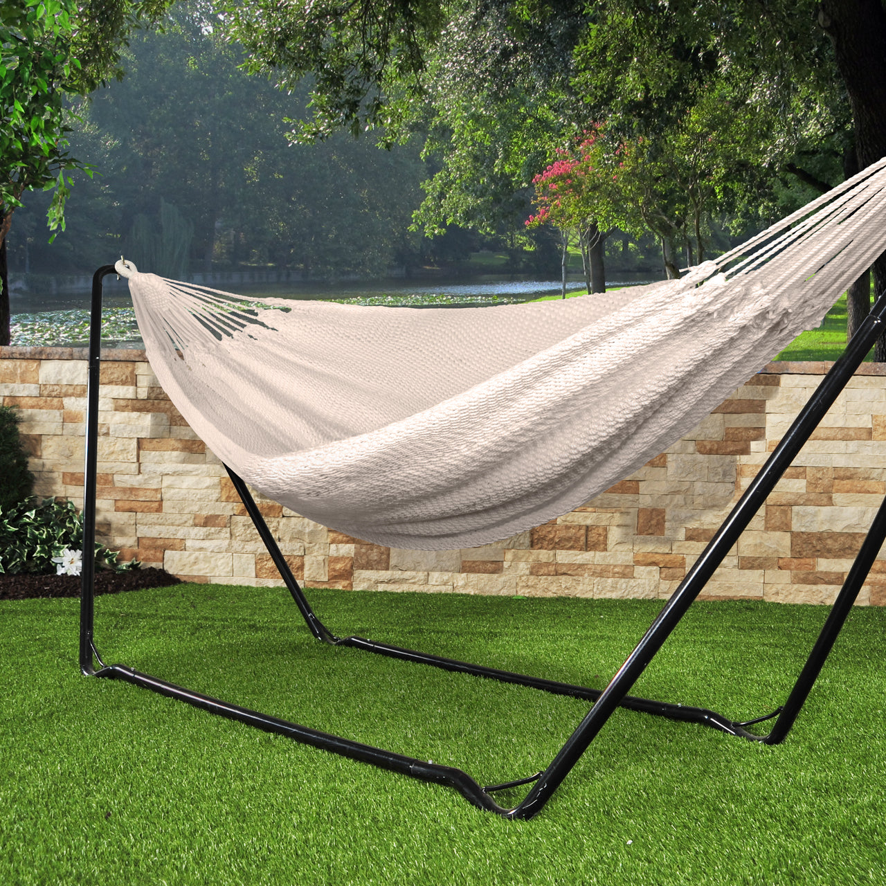 Bliss Hammocks 60-inch Wide Brazilian Style Oversized Rope Hammock with Braided Rope Ends attached to a Bliss Hammocks Stand in the grass.