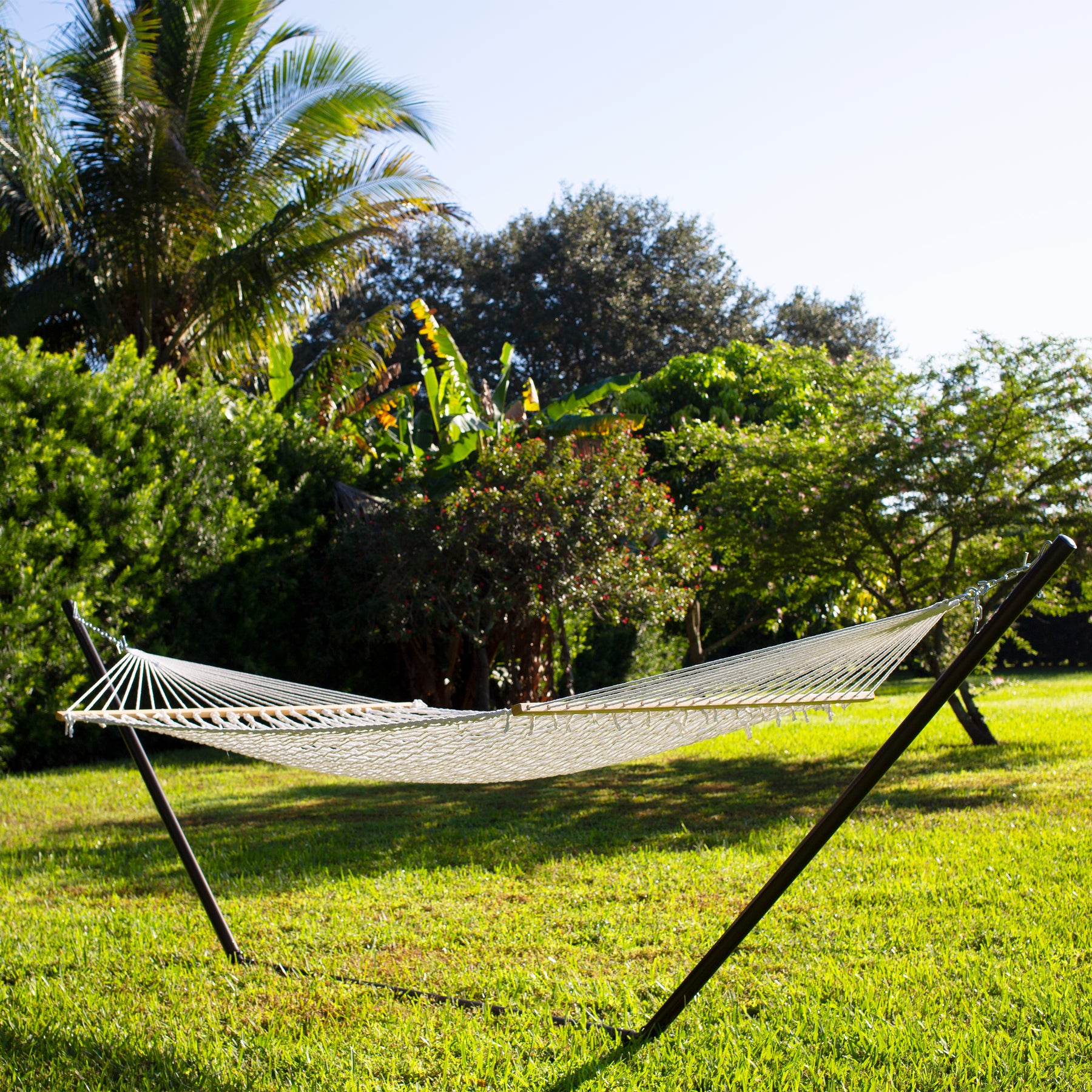 60-inch Wide White Cotton Rope Hammock secured to a stand outside on grass.