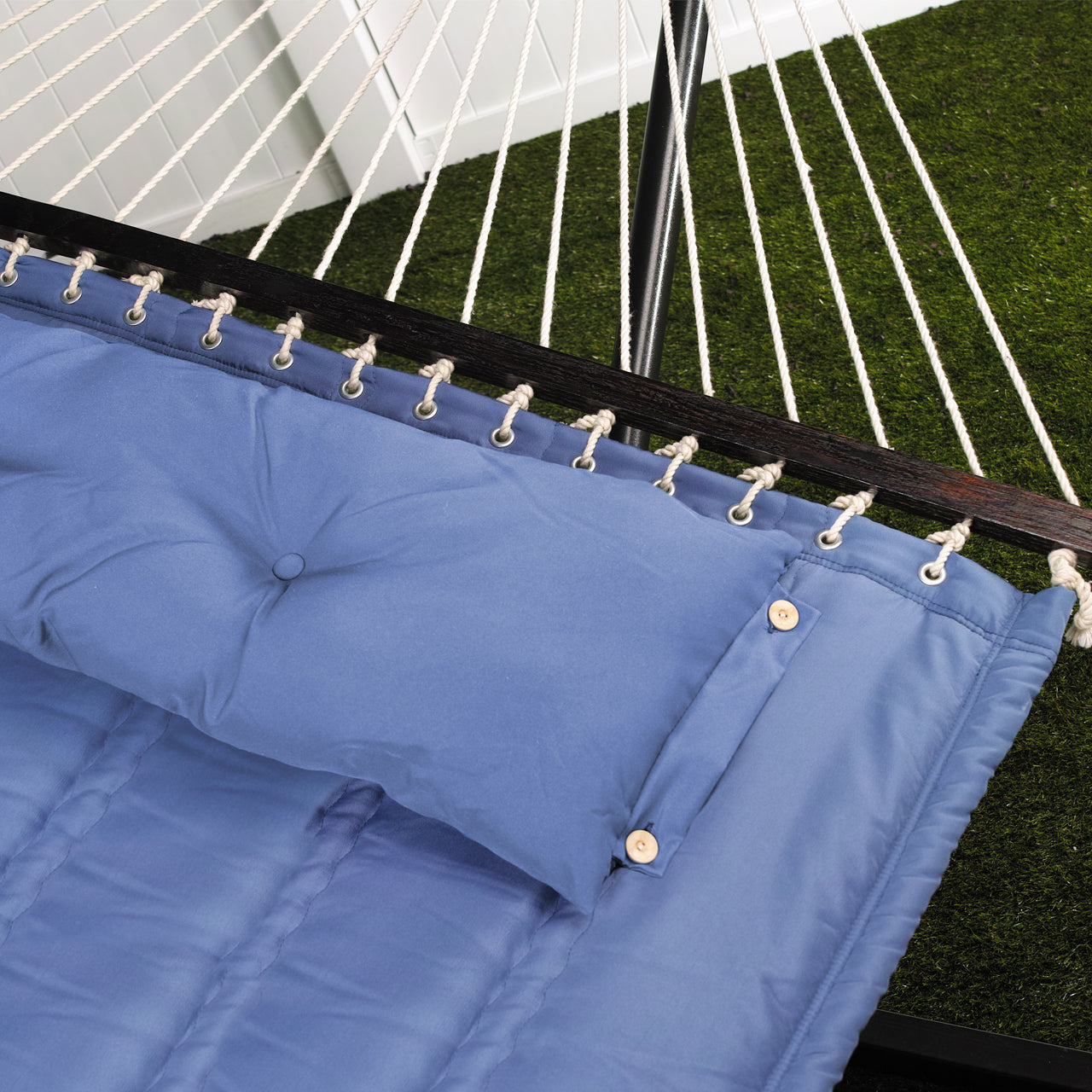 Close up of the fabric and spreader bar for the Bliss Hammocks 55-inch Wide Quilted Hammock with Spreader Bars and Pillow in the denim blue variation.