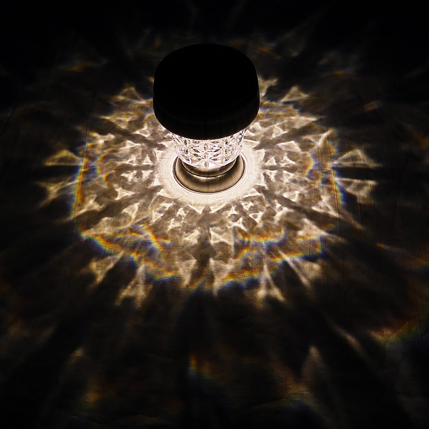 Bliss Outdoors 14-inch Tall Stainless Steel Solar Powered LED Pathway Light turned on and creating a cool triangle pattern from light on the surface around it.