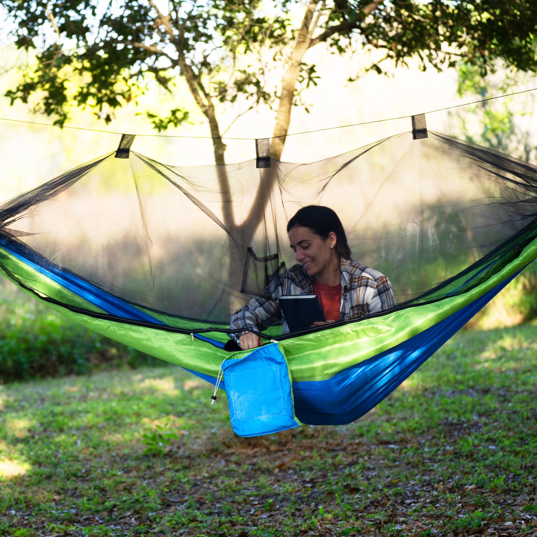 Woman zippering the mosquito net closed to protect her from insects.