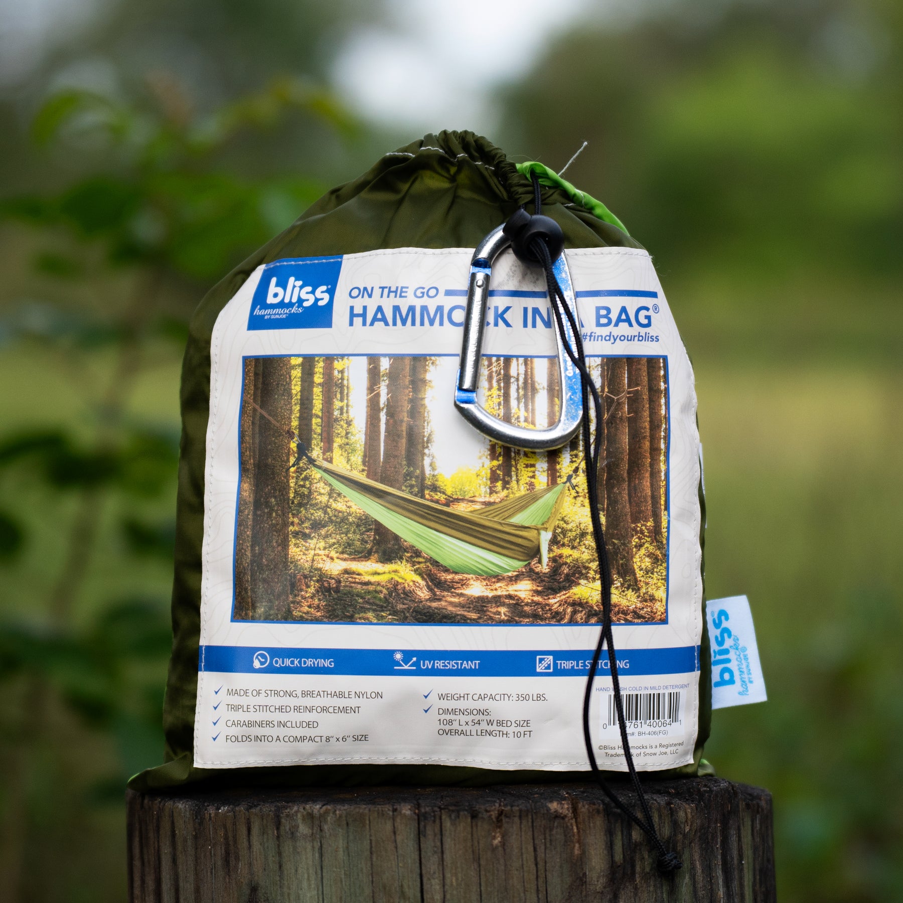 A packed Bliss Hammocks 54-inch Wide Hammock in a Bag sitting on a wooden stump.