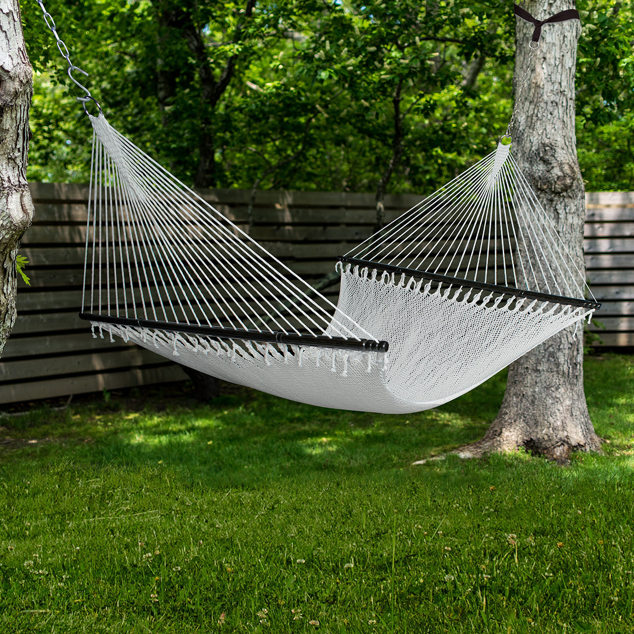 Bliss Hammocks 55-inch Wide 2-Person Weekender Deluxe Hammock with Spreader Bars hung outside between two trees.