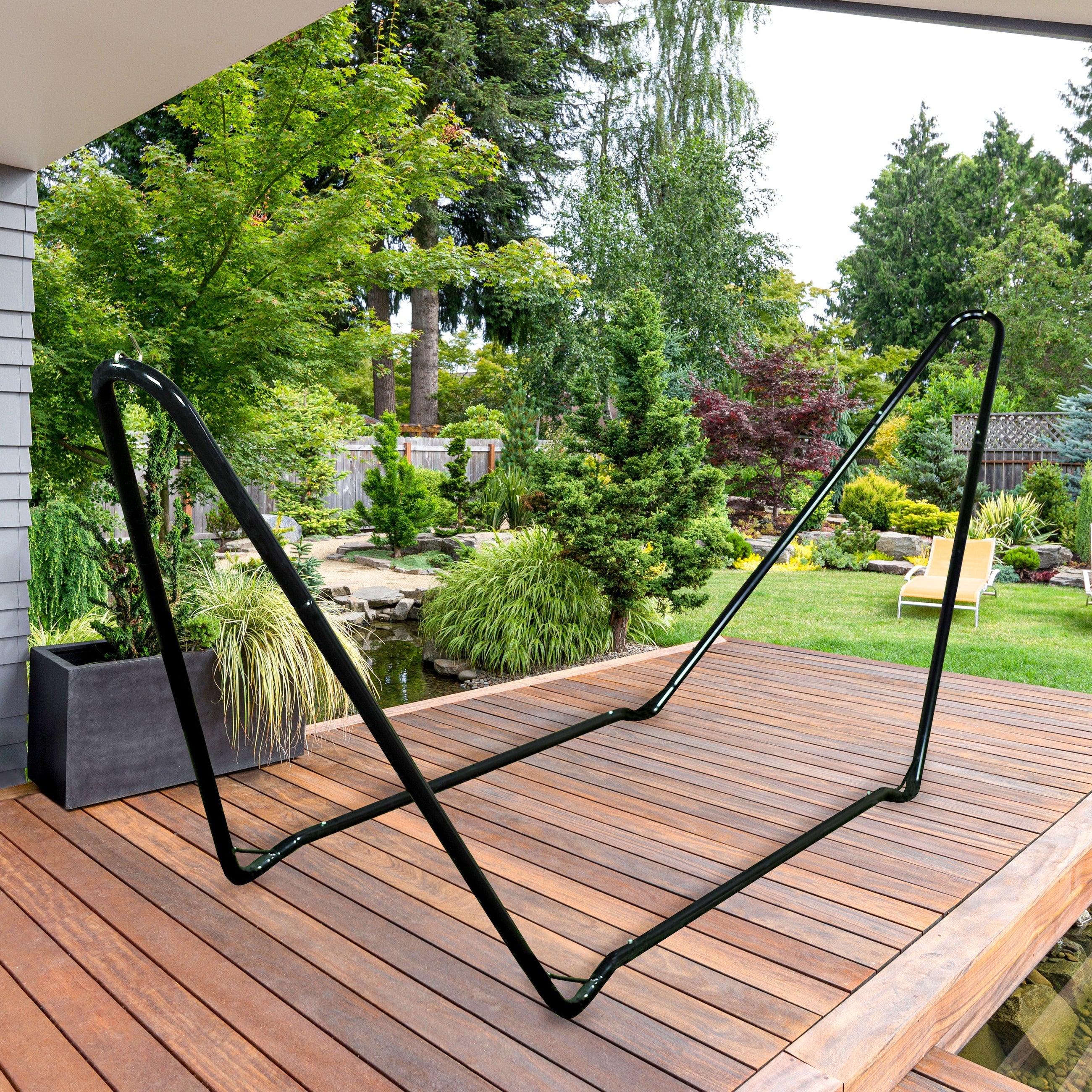 A hammock stand from Bliss Hammocks on a backyard patio - Stands