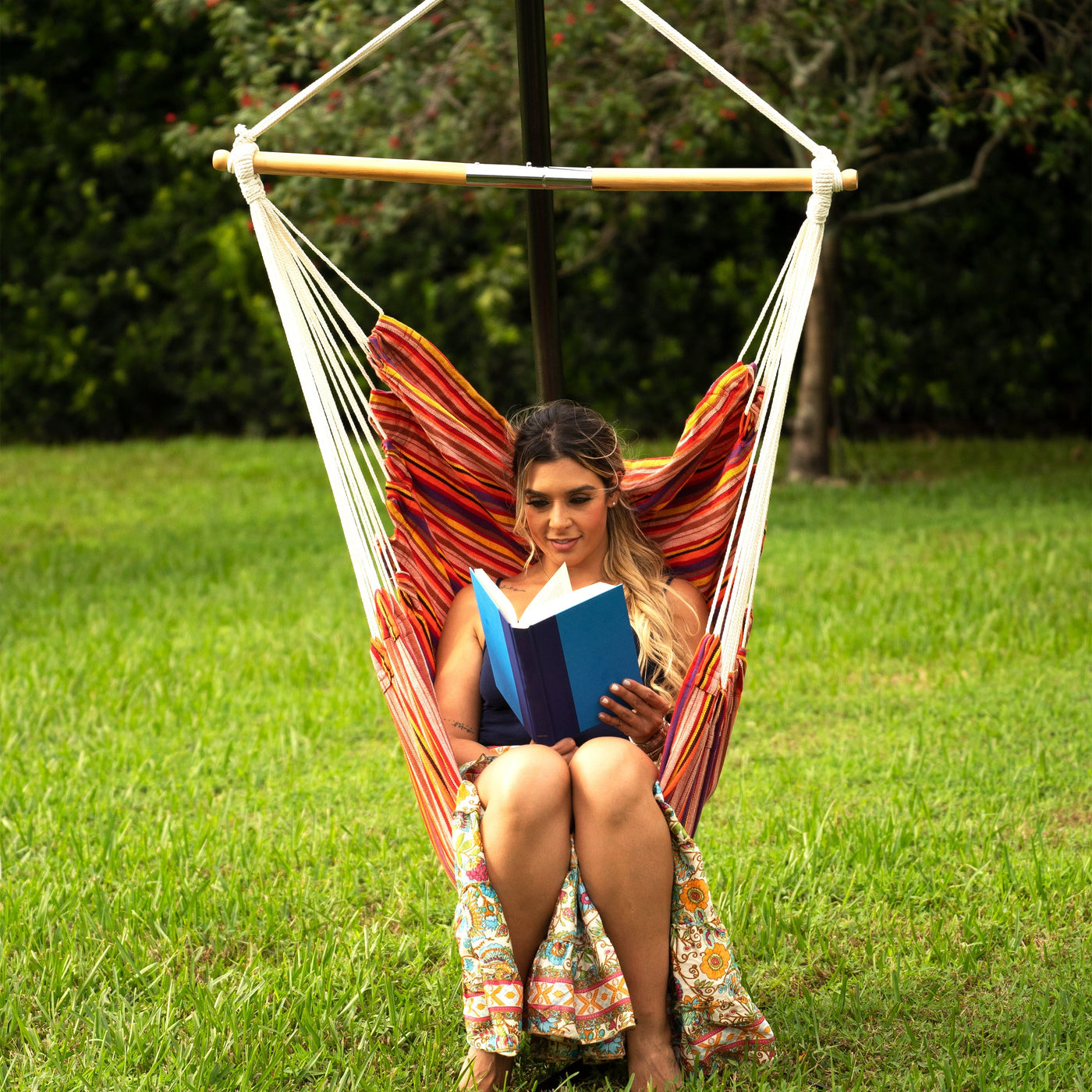 Woman reading a book while relaxing in a Bliss Hammocks Hanging Chair - Hammock Chairs
