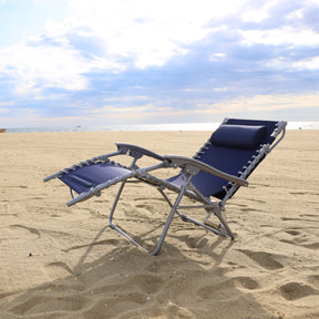 Navy beach recliner reclined on the sand.