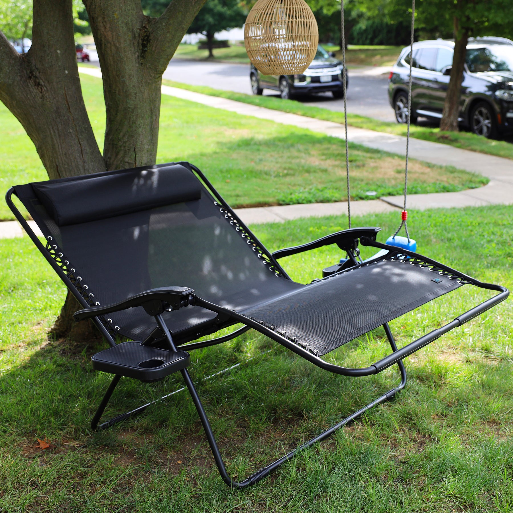 45-inch 2-Person Black Zero Gravity Chair reclined on a lawn under a tree.
