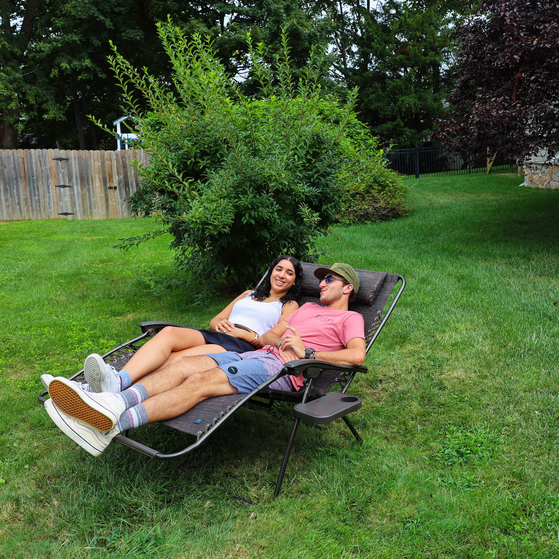 Couple reclined in the 45-inch 2-Person Brown Jacquard Zero Gravity Chair.