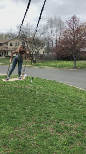 Girl using the Bliss Outdoors Skateboard swing in the front yard.