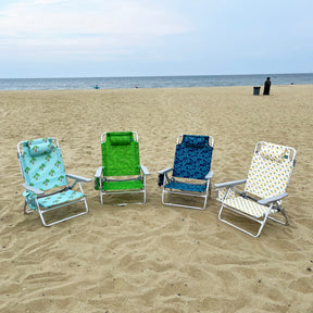 4 folding beach chairs on the sand, each with a different color and pattern.