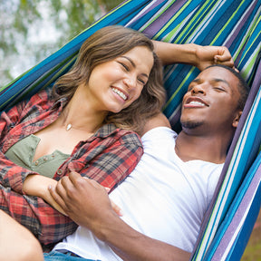 Man and women relaxing in a Bliss Hammocks 60" Wide Double Hammock and smiling.