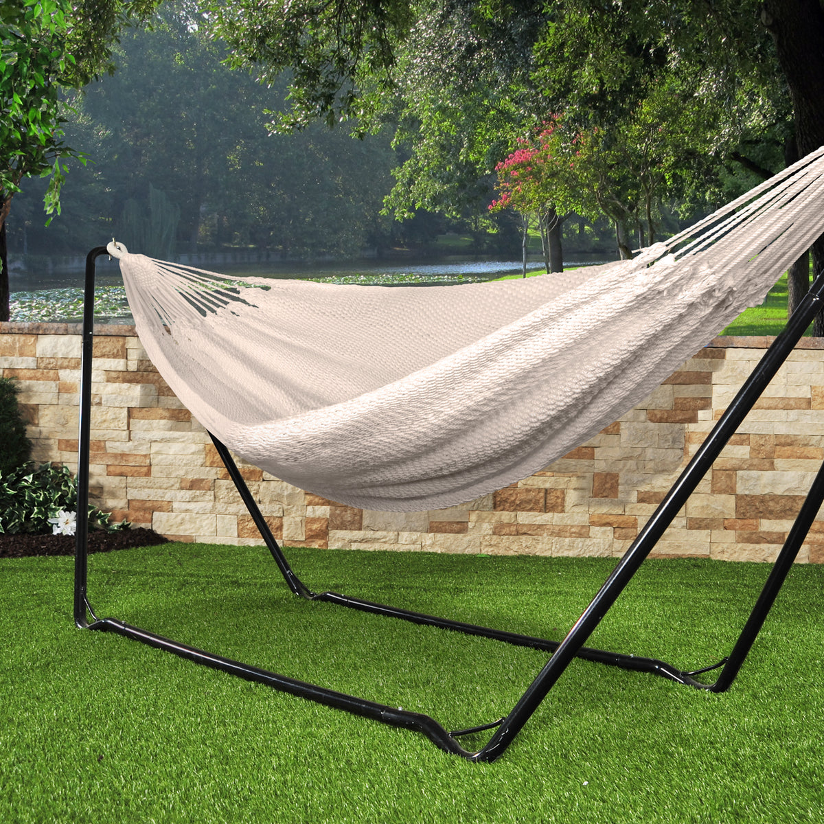 Bliss Hammocks 60-inch Wide Brazilian Style Oversized Rope Hammock with Braided Rope Ends attached to a Bliss Hammocks Stand in the grass.