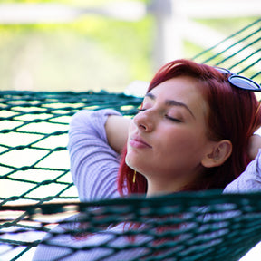 Close-up of a girl relaxing in the Bliss Hammocks 60-inch Wide Cotton Rope Hammock.