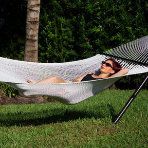 Woman relaxing in the sun on the 55-inch 2-person hammock.