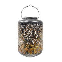 Bliss Outdoors 12-inch Tall Hanging and Tabletop Decorative Solar LED Lantern with Unique Tropical Leaf Design and Antique Hand Painted Finish in the brushed silver variation.