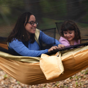 Woman and young girl sitting in a Bliss Hammocks 54-inch Wide Hammock in a Bag with mosquito net.