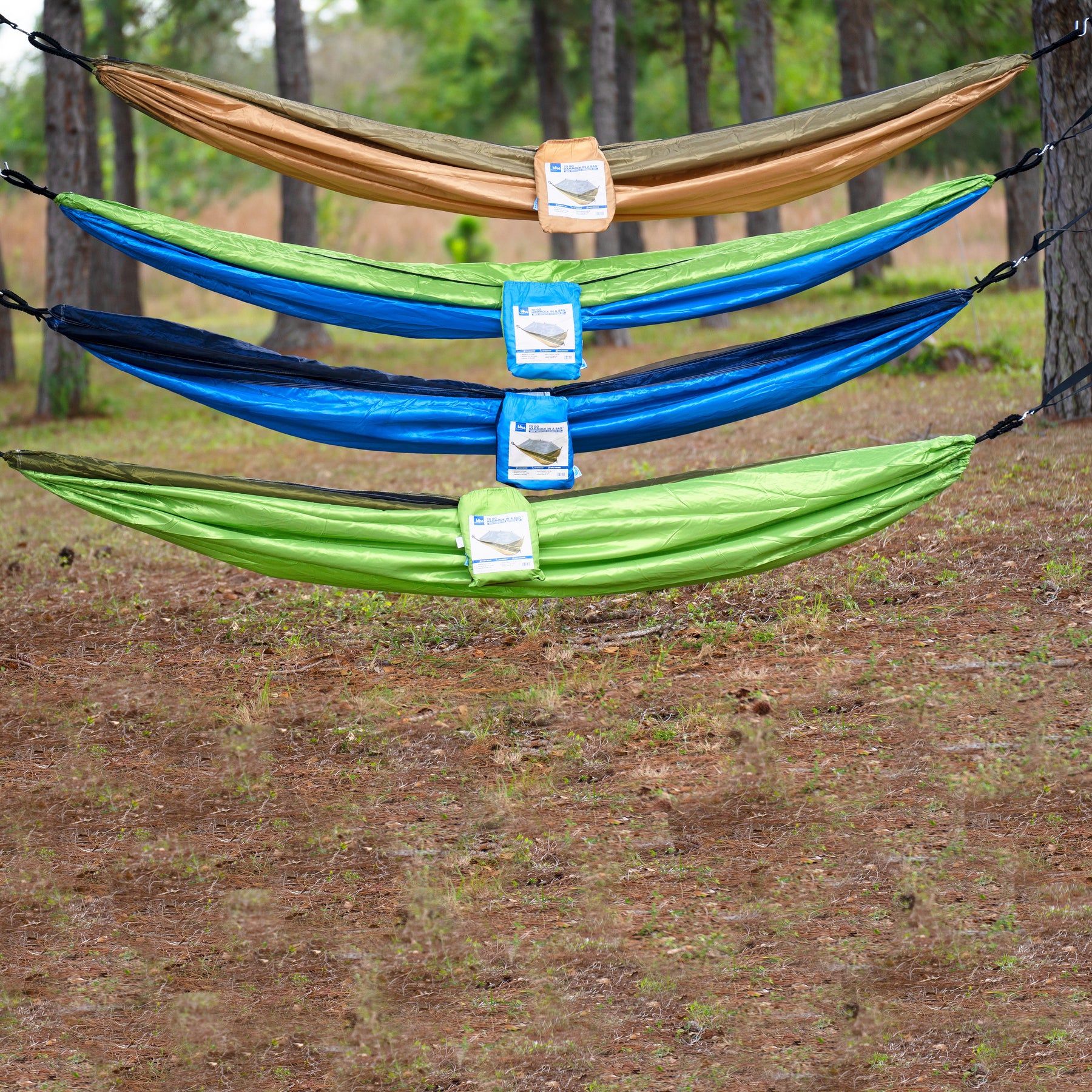 All four hammock variations hung in the woods between two trees.