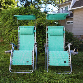 Set of 2 26-inch Teal Genome Zero Gravity Chairs on a lawn.