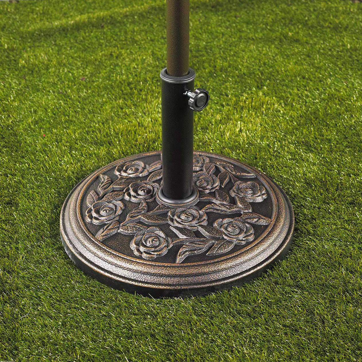 Bliss Outdoors Heavy-Duty Umbrella Base in the rose variation in grass with an umbrella inside.